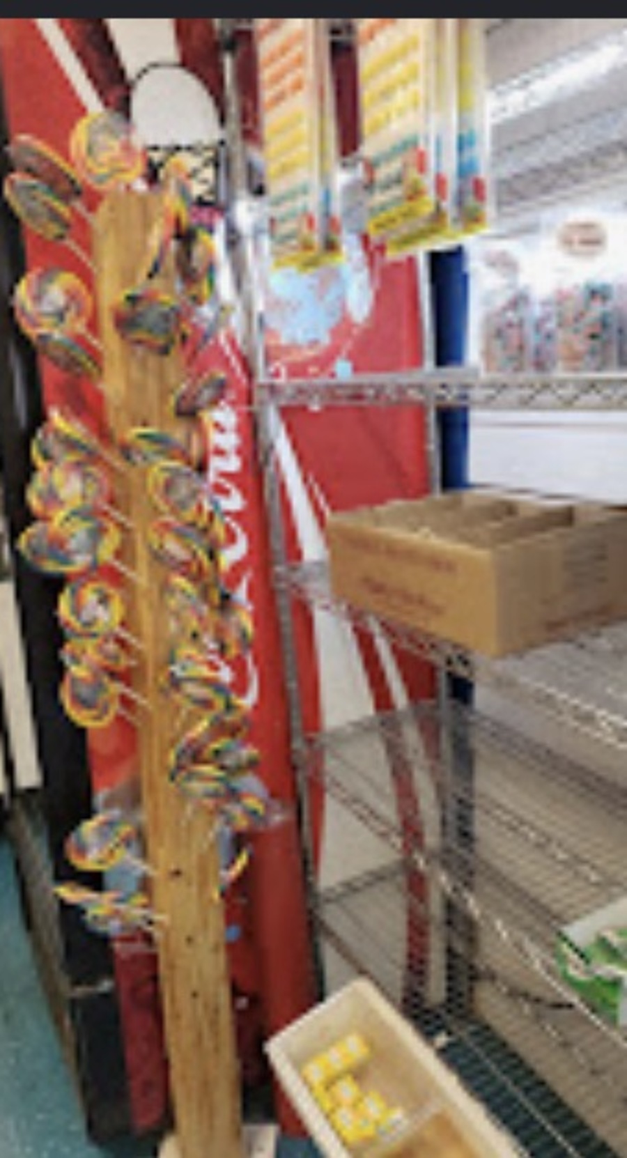 Wooden lollipop tree holding giant swirl lollipops beside a Coca-Cola cooler